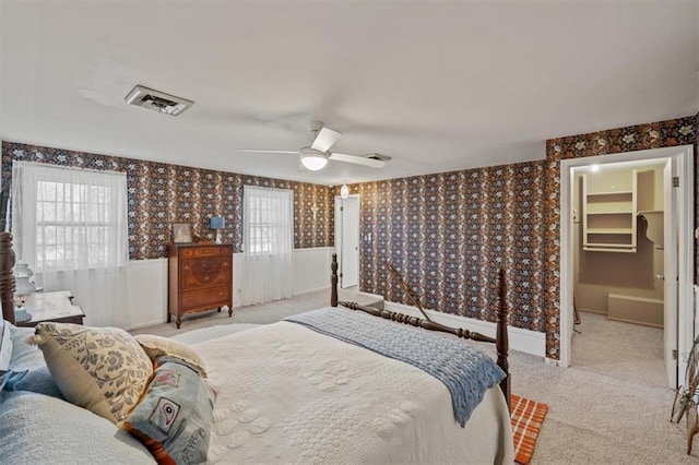 bedroom with wallpapered walls, multiple windows, visible vents, and carpet flooring