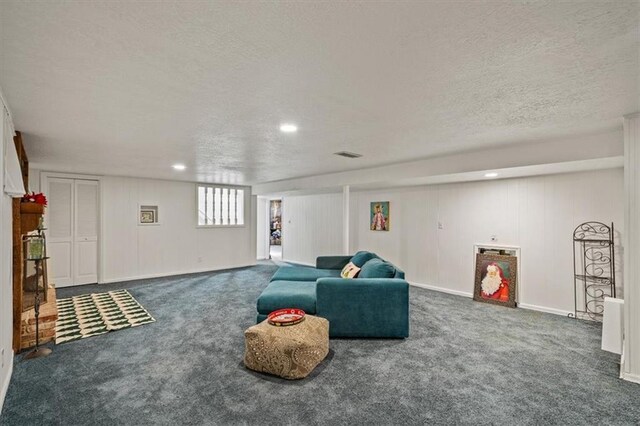 carpeted living room featuring baseboards, visible vents, a textured ceiling, and recessed lighting