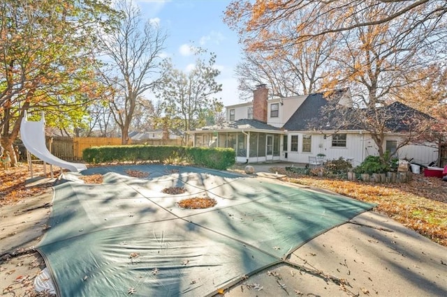 view of pool featuring fence and a sunroom