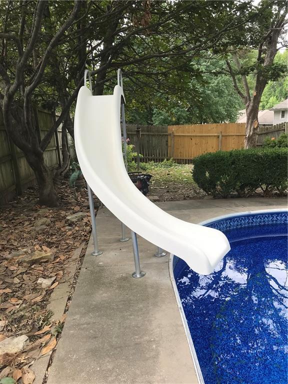 view of pool featuring a fenced in pool, fence, and a water slide