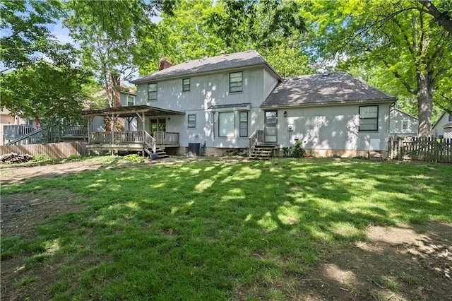 back of property featuring a lawn and a wooden deck