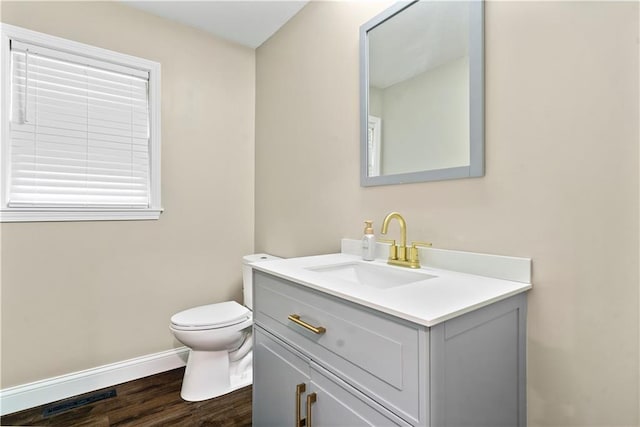 bathroom with vanity, toilet, and wood-type flooring