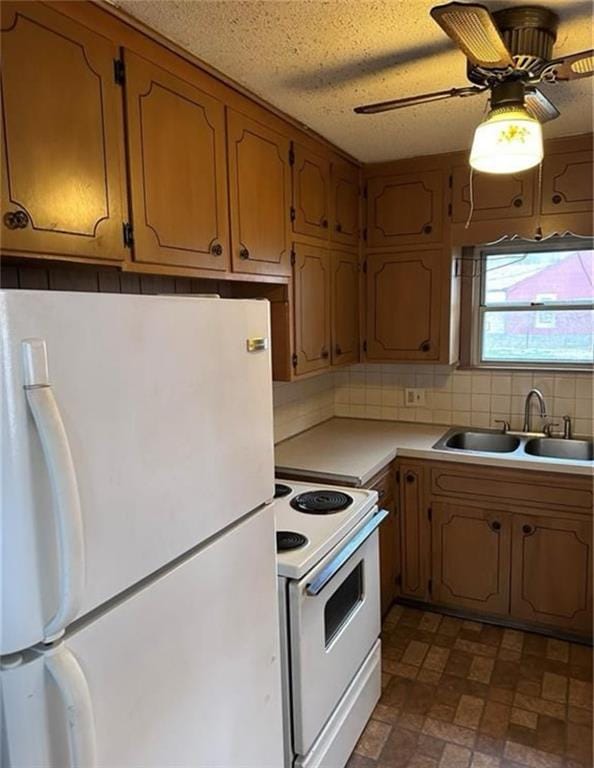 kitchen featuring white appliances, sink, ceiling fan, decorative backsplash, and a textured ceiling