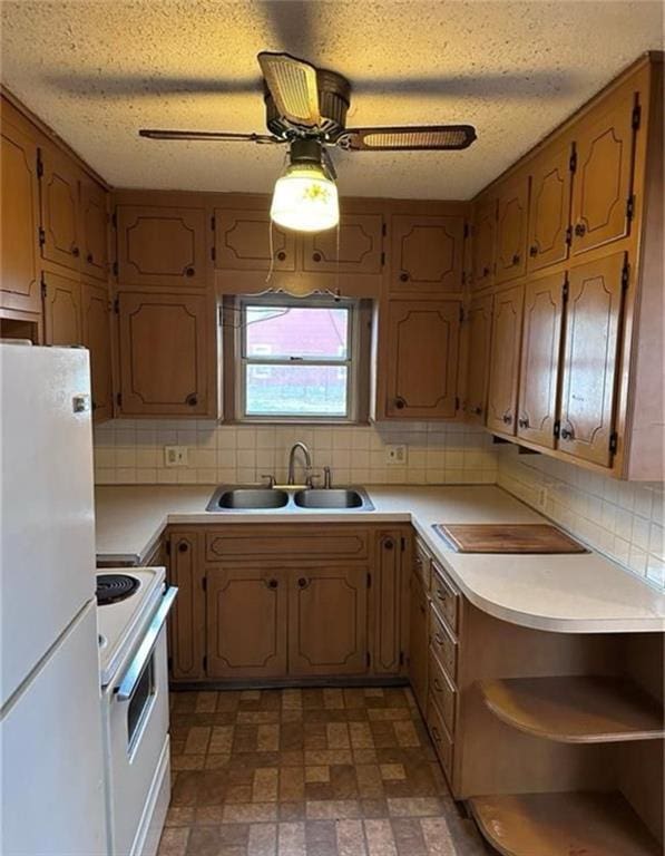 kitchen featuring a textured ceiling, white appliances, tasteful backsplash, and sink