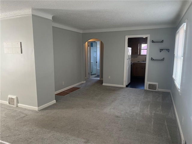 spare room with dark carpet and a textured ceiling