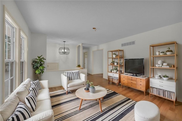 living room featuring a chandelier and light wood-type flooring