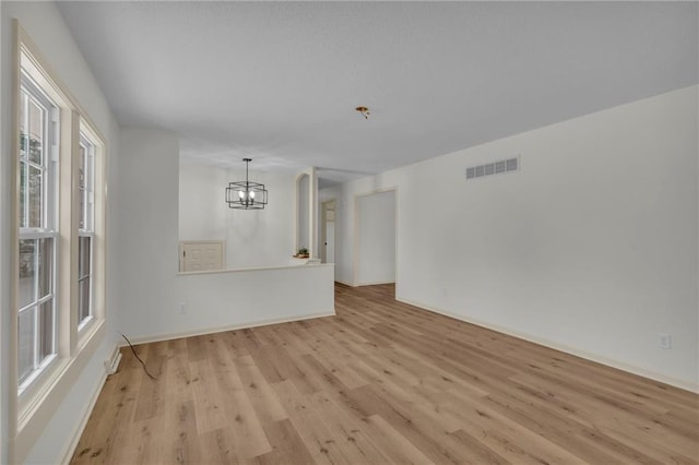 empty room featuring light hardwood / wood-style floors and an inviting chandelier