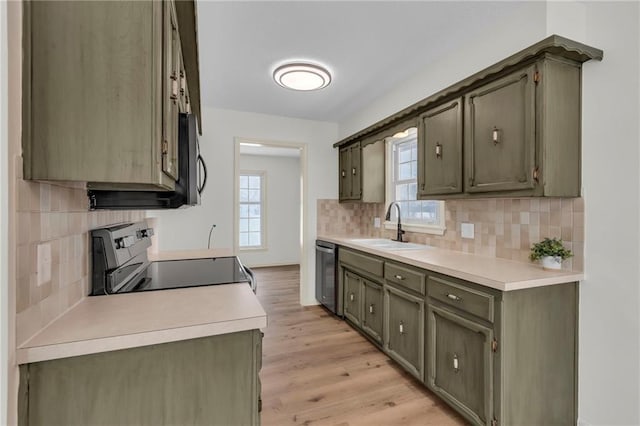 kitchen featuring decorative backsplash, sink, light hardwood / wood-style flooring, dishwasher, and range