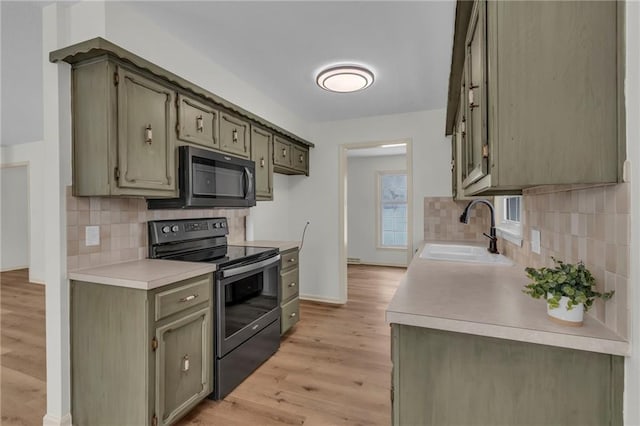 kitchen featuring tasteful backsplash, black range with electric cooktop, sink, light hardwood / wood-style flooring, and green cabinets