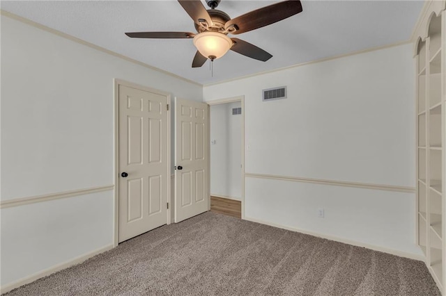 carpeted empty room featuring crown molding and ceiling fan