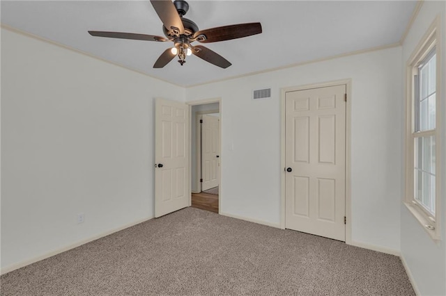 unfurnished bedroom featuring multiple windows, ceiling fan, and carpet floors