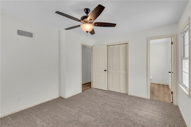 unfurnished bedroom with carpet flooring, ceiling fan, and a closet