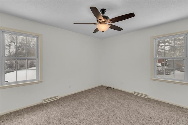 carpeted spare room featuring ceiling fan