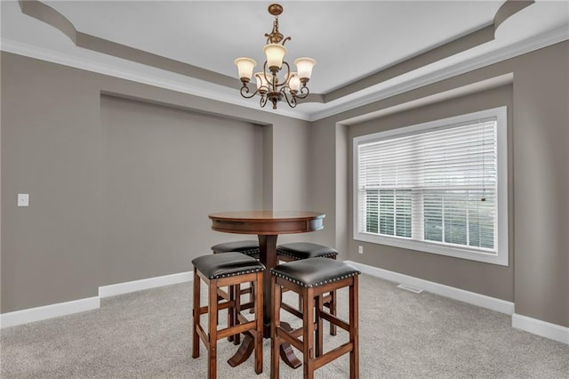 carpeted dining room with a tray ceiling, a notable chandelier, and ornamental molding