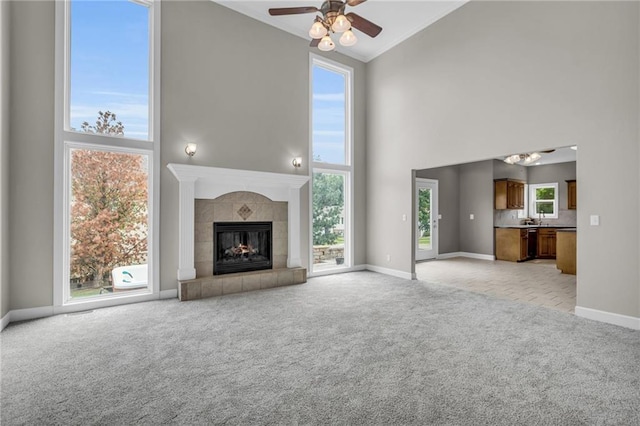 unfurnished living room with a wealth of natural light, a fireplace, and high vaulted ceiling