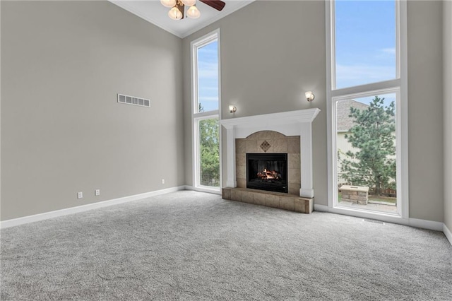 unfurnished living room featuring a healthy amount of sunlight, a high ceiling, and ornamental molding