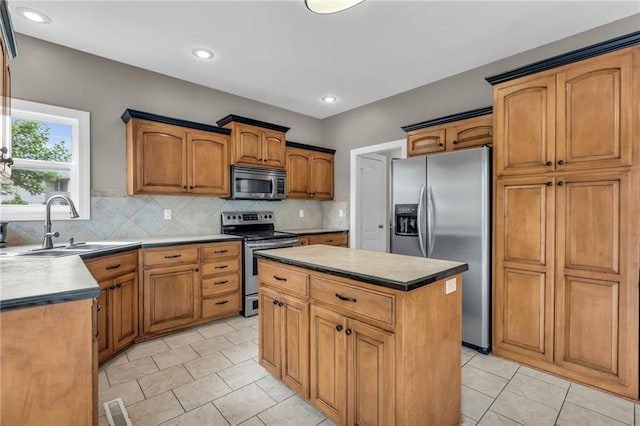 kitchen with decorative backsplash, a center island, stainless steel appliances, and sink