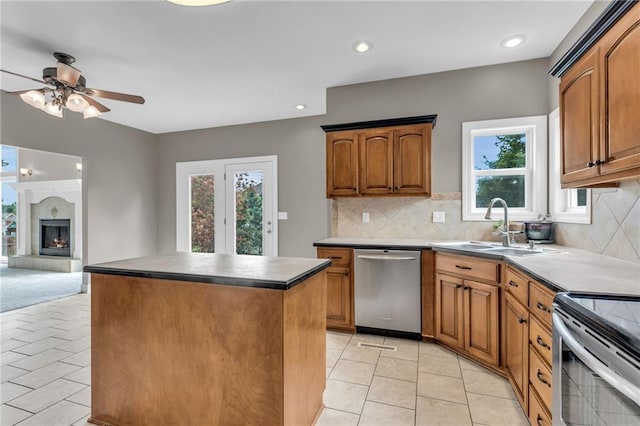 kitchen featuring stainless steel appliances, a kitchen island, plenty of natural light, and sink