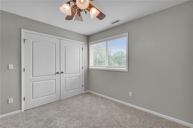 unfurnished bedroom with ceiling fan, a closet, and light colored carpet