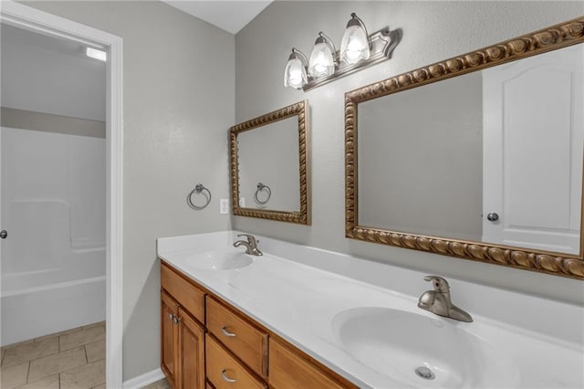 bathroom with tile patterned flooring, vanity, and walk in shower