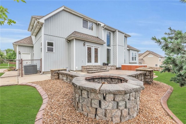 back of property featuring a hot tub and a fire pit