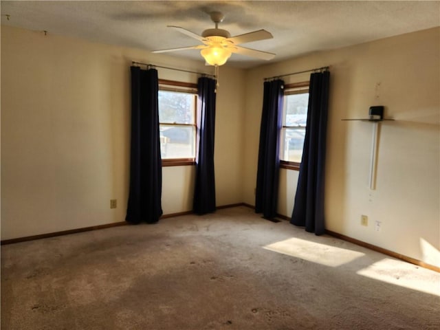 unfurnished room with ceiling fan, light colored carpet, and a healthy amount of sunlight