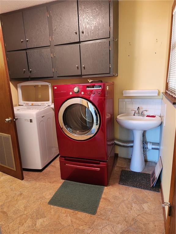 laundry room featuring independent washer and dryer and cabinets