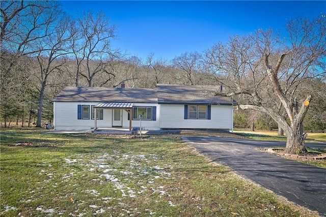 single story home featuring aphalt driveway and a front yard