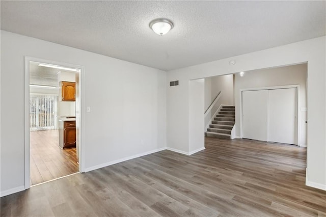 empty room featuring a textured ceiling and hardwood / wood-style flooring