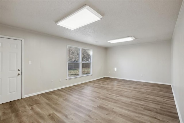 spare room featuring wood-type flooring and a textured ceiling