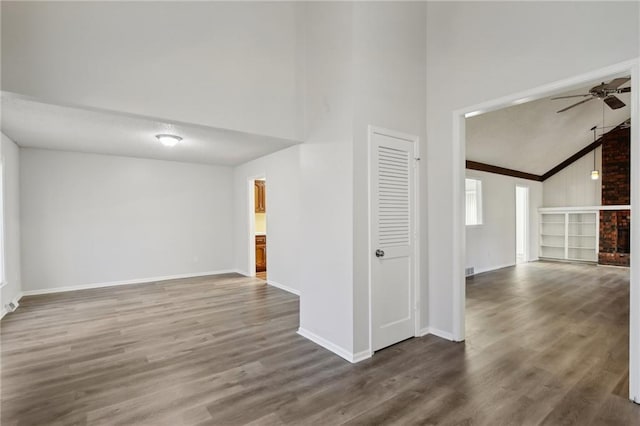 unfurnished room featuring ceiling fan, dark hardwood / wood-style flooring, high vaulted ceiling, and ornamental molding