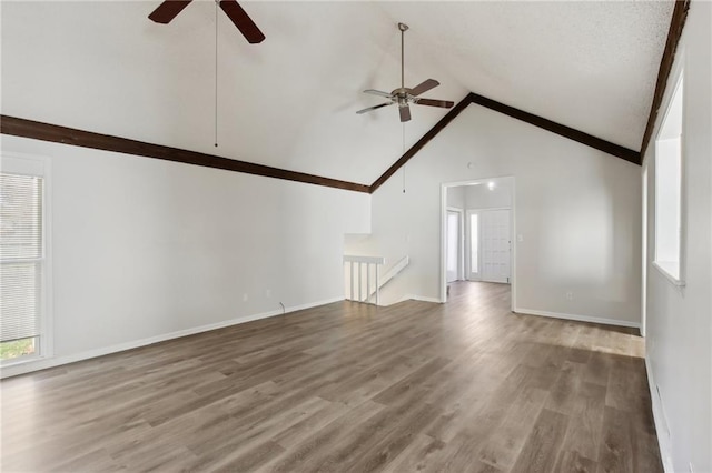 unfurnished living room with ceiling fan, wood-type flooring, and high vaulted ceiling