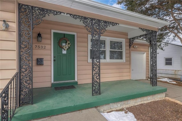 view of exterior entry with a garage and covered porch