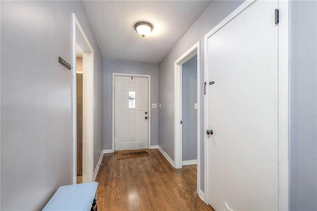 doorway with light hardwood / wood-style flooring and a textured ceiling