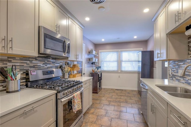 kitchen with appliances with stainless steel finishes, sink, and backsplash