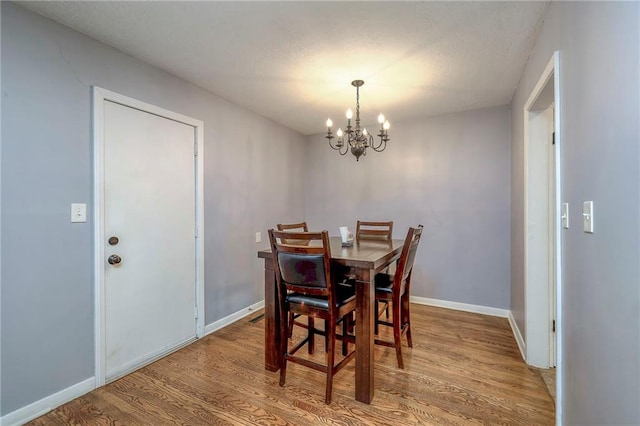 dining area featuring hardwood / wood-style flooring and a chandelier