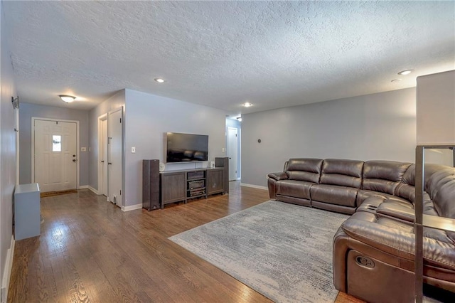 living room with wood-type flooring and a textured ceiling