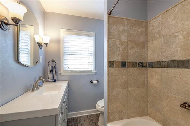 full bathroom featuring vanity, hardwood / wood-style flooring, toilet, and tiled shower / bath