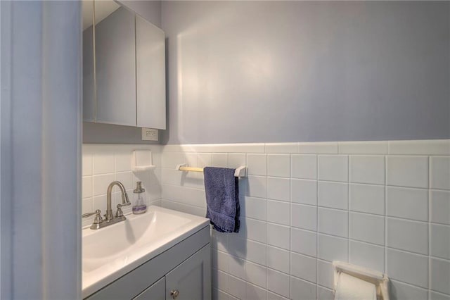 bathroom with vanity and tile walls