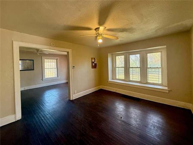 spare room with a textured ceiling, dark hardwood / wood-style flooring, and ceiling fan