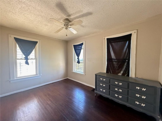 unfurnished bedroom with multiple windows, a textured ceiling, ceiling fan, and dark wood-type flooring