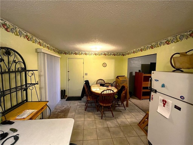 tiled dining space featuring a textured ceiling