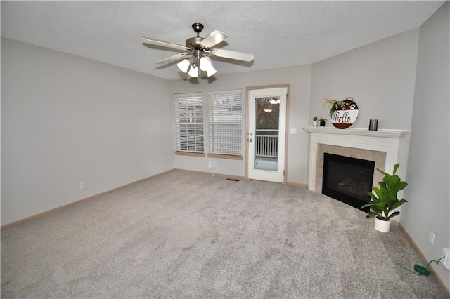 unfurnished living room featuring carpet flooring, a fireplace, a textured ceiling, and baseboards