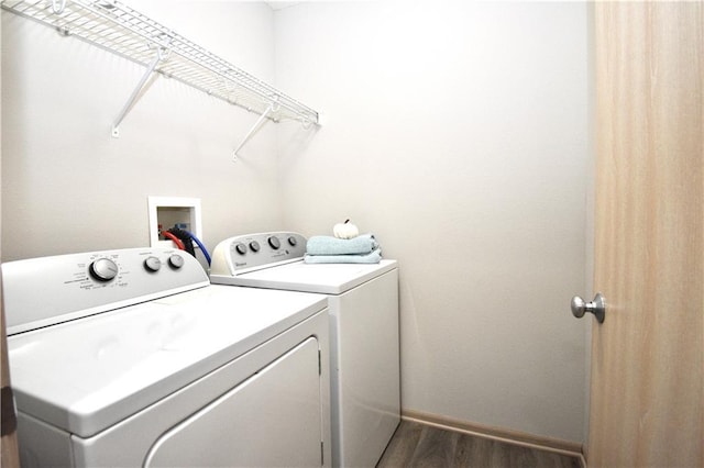 laundry area featuring laundry area, dark wood-type flooring, washing machine and dryer, and baseboards