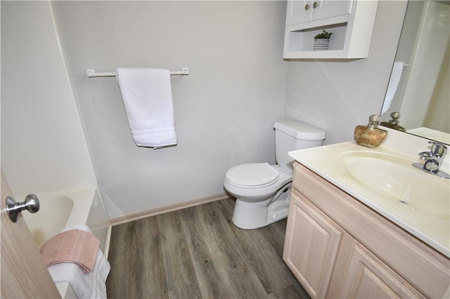 bathroom with toilet, wood finished floors, and vanity