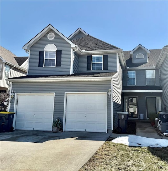 traditional-style home featuring an attached garage and driveway