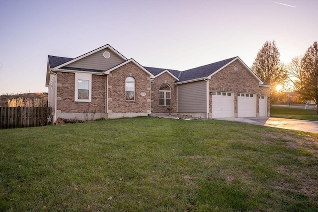 ranch-style home featuring a lawn and a garage