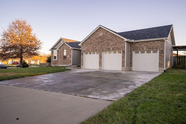 ranch-style house featuring a garage and a lawn