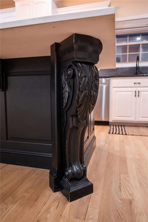 room details featuring sink, hardwood / wood-style floors, and stainless steel dishwasher