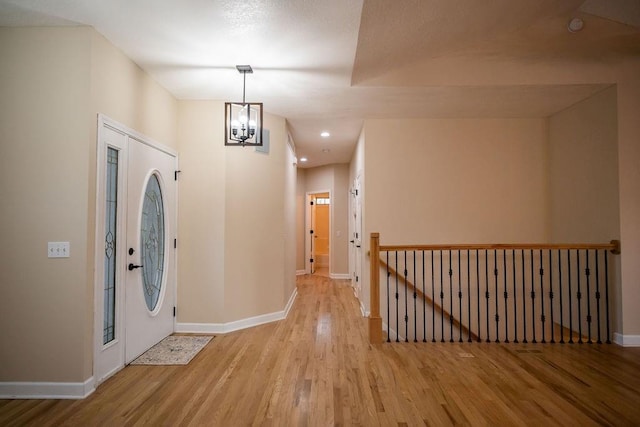 entrance foyer with light hardwood / wood-style floors and a chandelier